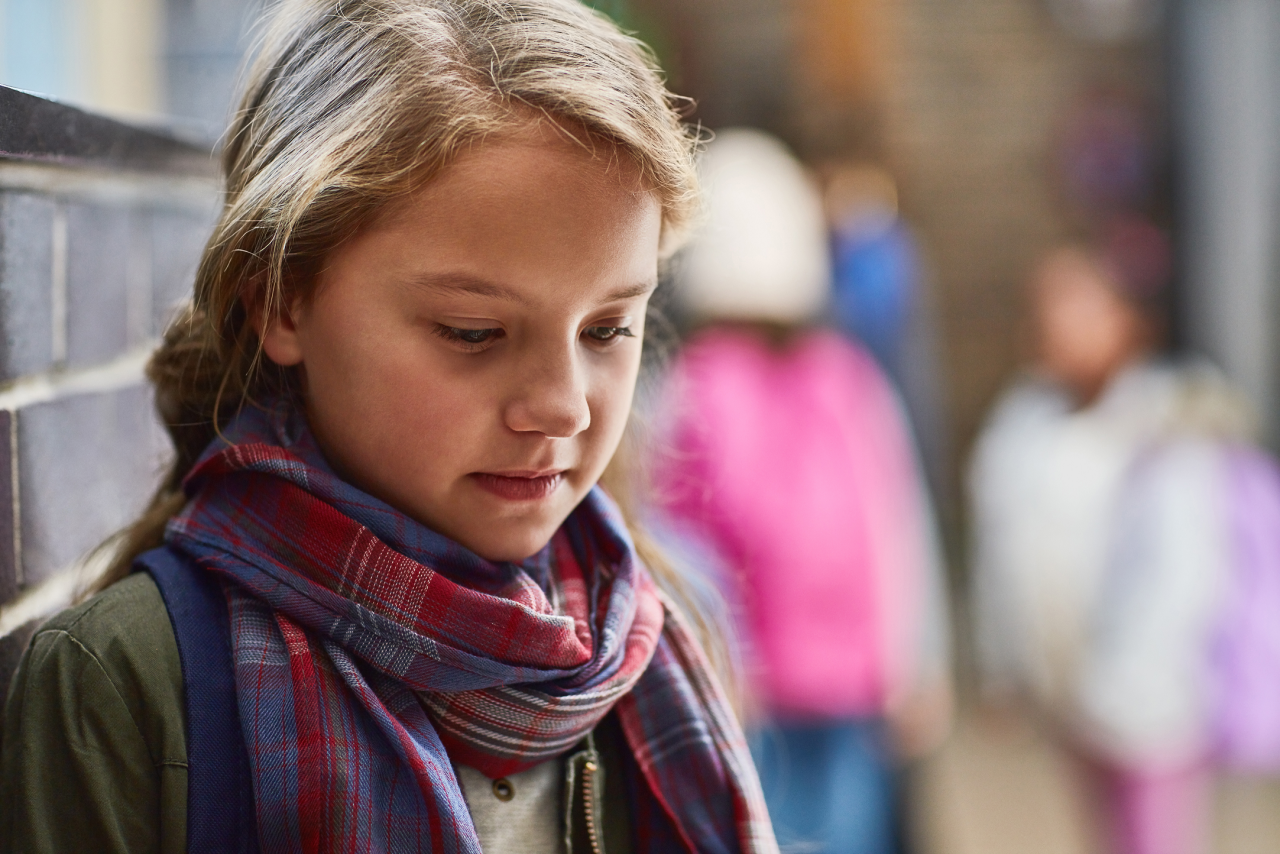 Mädchen in der Schule, alleine, in sich gekehrt