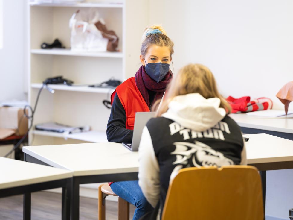 Junge Frau berät andere zum Thema Covid