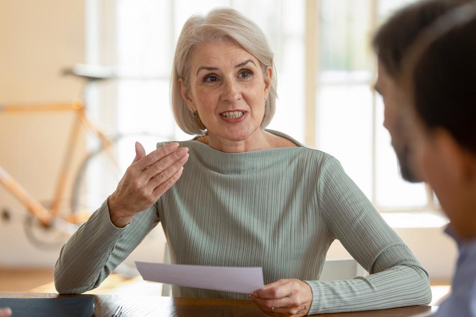 Ältere Frau spricht zu einer Gruppe