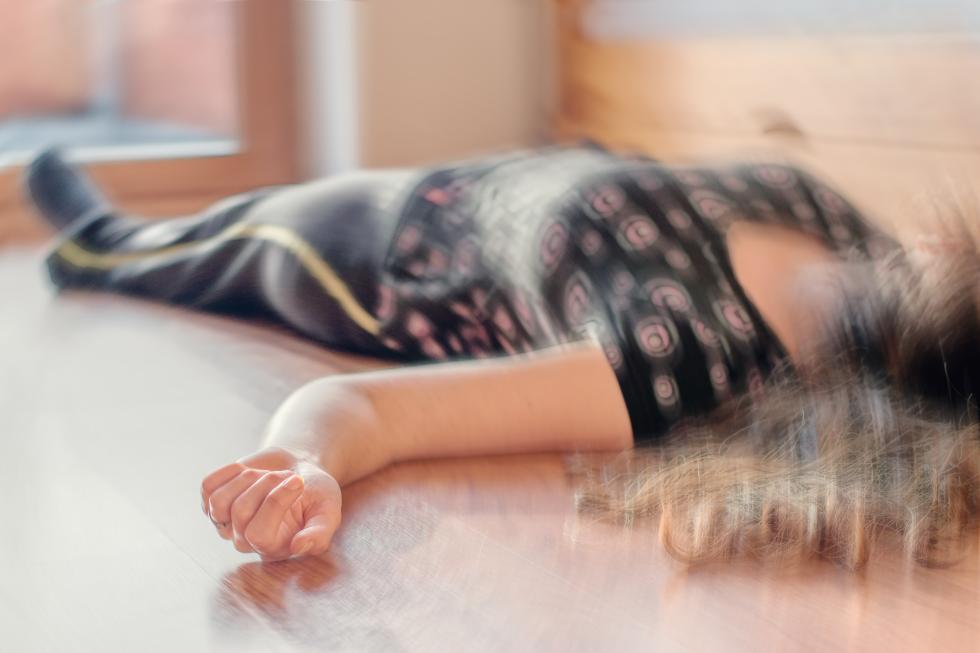 Frau liegt bewusstlos auf dem Boden
